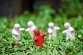 4 white ceramic dolls ÃÂ But there is 1 red one, green background with bokeh